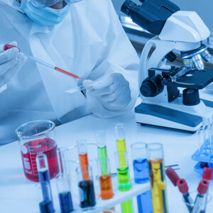 image of a medical lab with test tubes, technician, and microscope