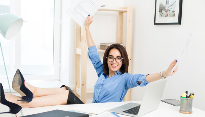 Happy, energized, ready to work woman behind a desk.